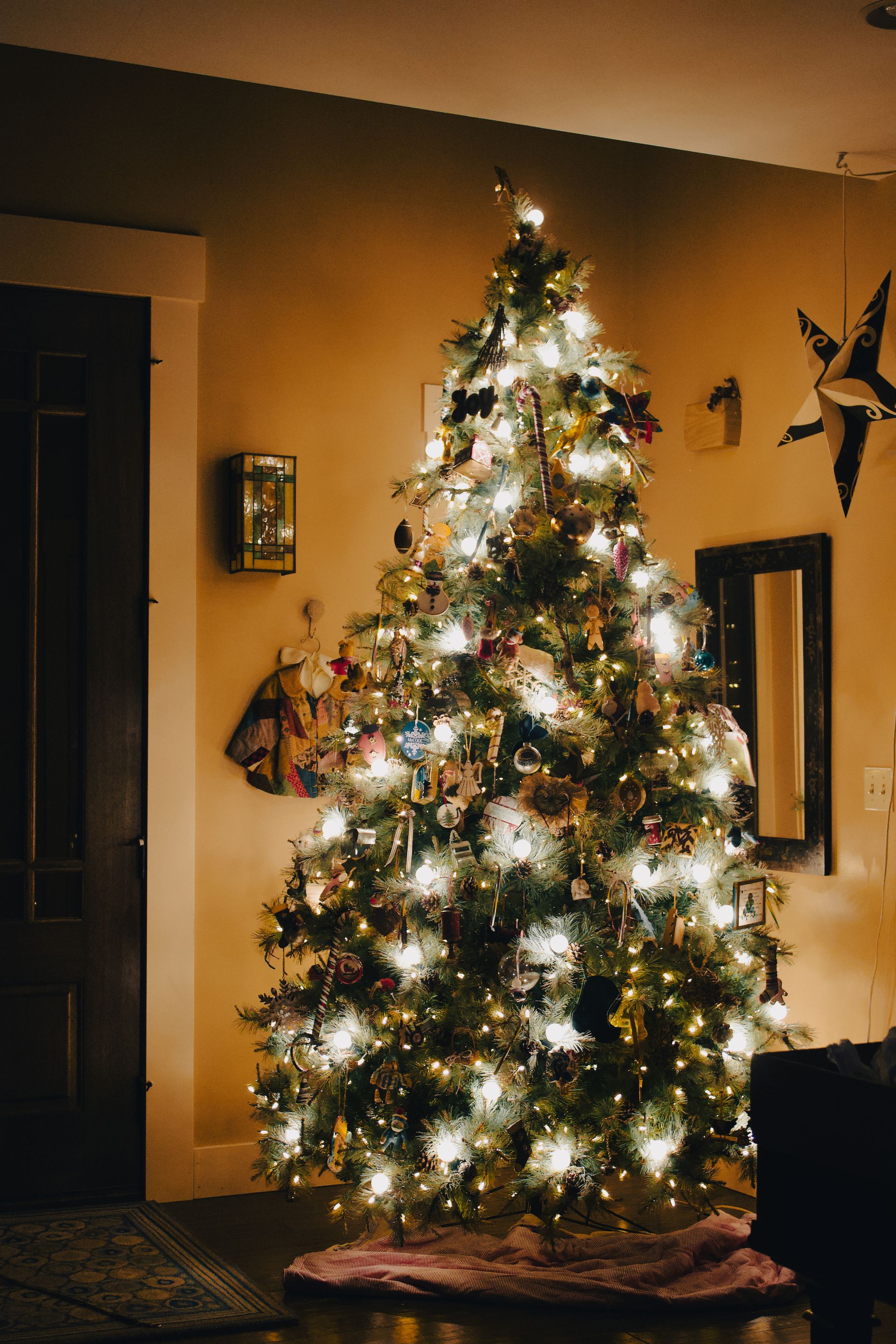 Christmas tree glowing with warm white lights in a cozy holiday room